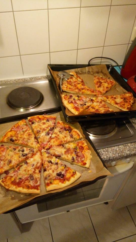Freshly baked homemade pizza sliced on trays