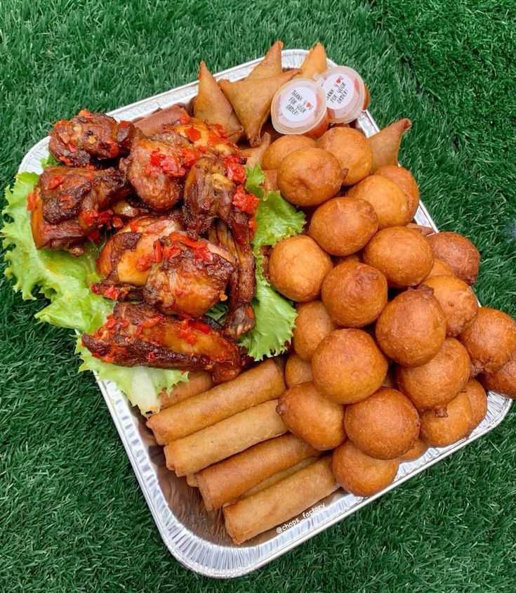 A full tray of Nigerian small chops with puff-puff, samosa and chicken
